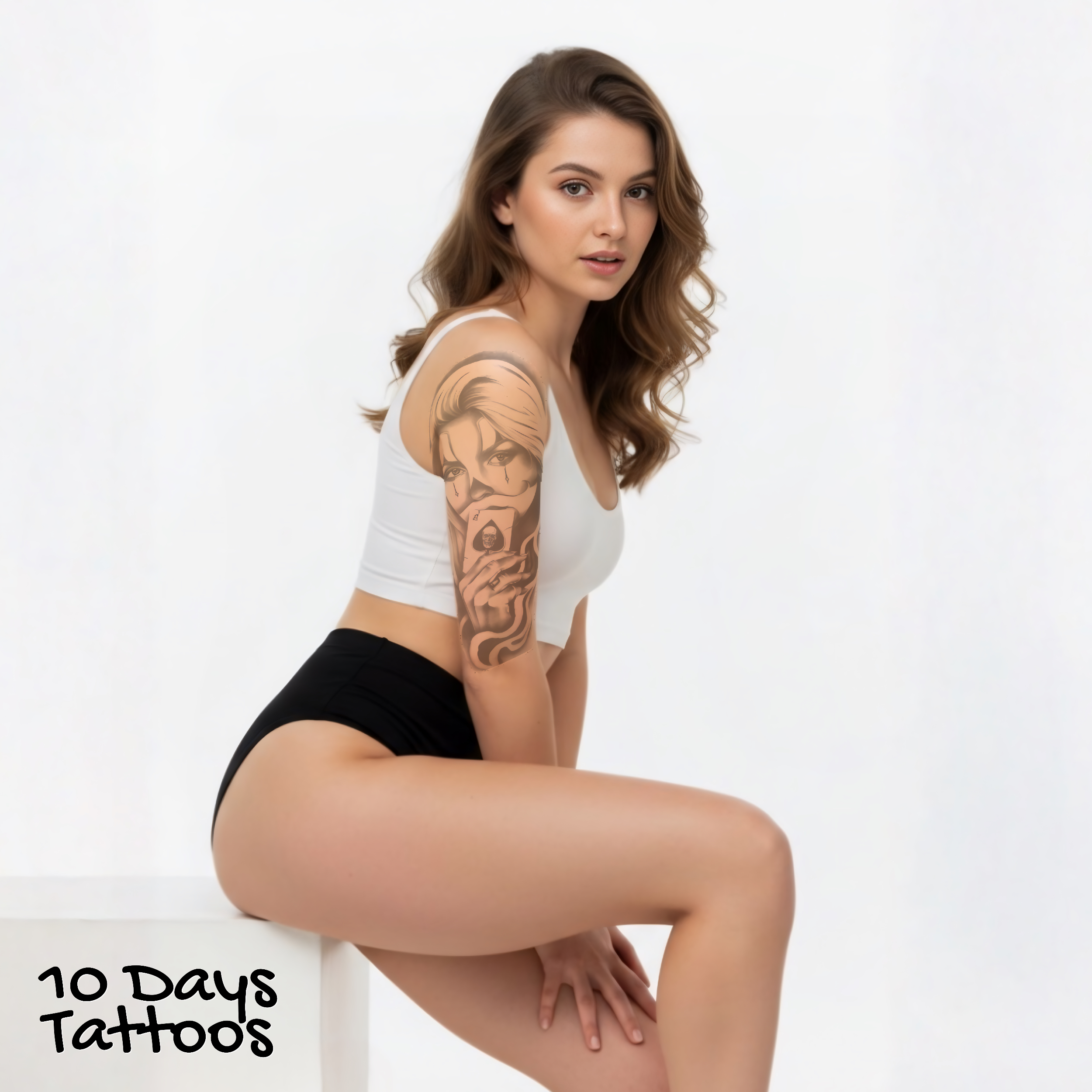 Jeune femme assise en short avec tatouage Black Smoke Grace, visage féminin et carte d’as sur le bras droit