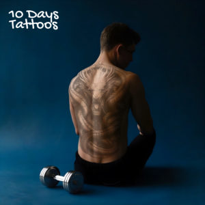 Jeune homme assis sur fond bleu avec altère, tatouage semi-permanent Roi des Serpents sur le dos