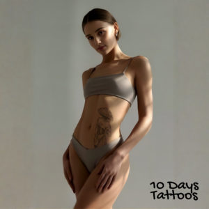 Jeune femme sexy avec tatouage blackwork Muse des Champignons sur le ventre
