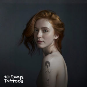 Jeune femme avec tatouage silhouette à capuche en style blackwork sur l’épaule gauche