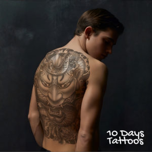 Jeune homme de dos avec tatouage semi-permanent japonais "Gardien" masque Oni et dragon couvrant tout le dos