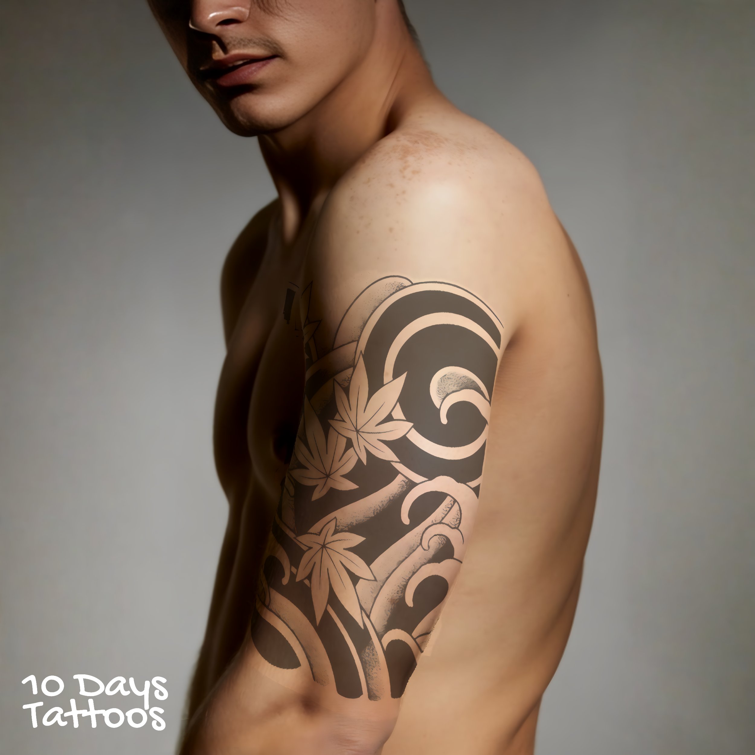 Jeune homme debout avec tatouage Nami no Bi, fleurs et vague japonaise, sur le bras gauche