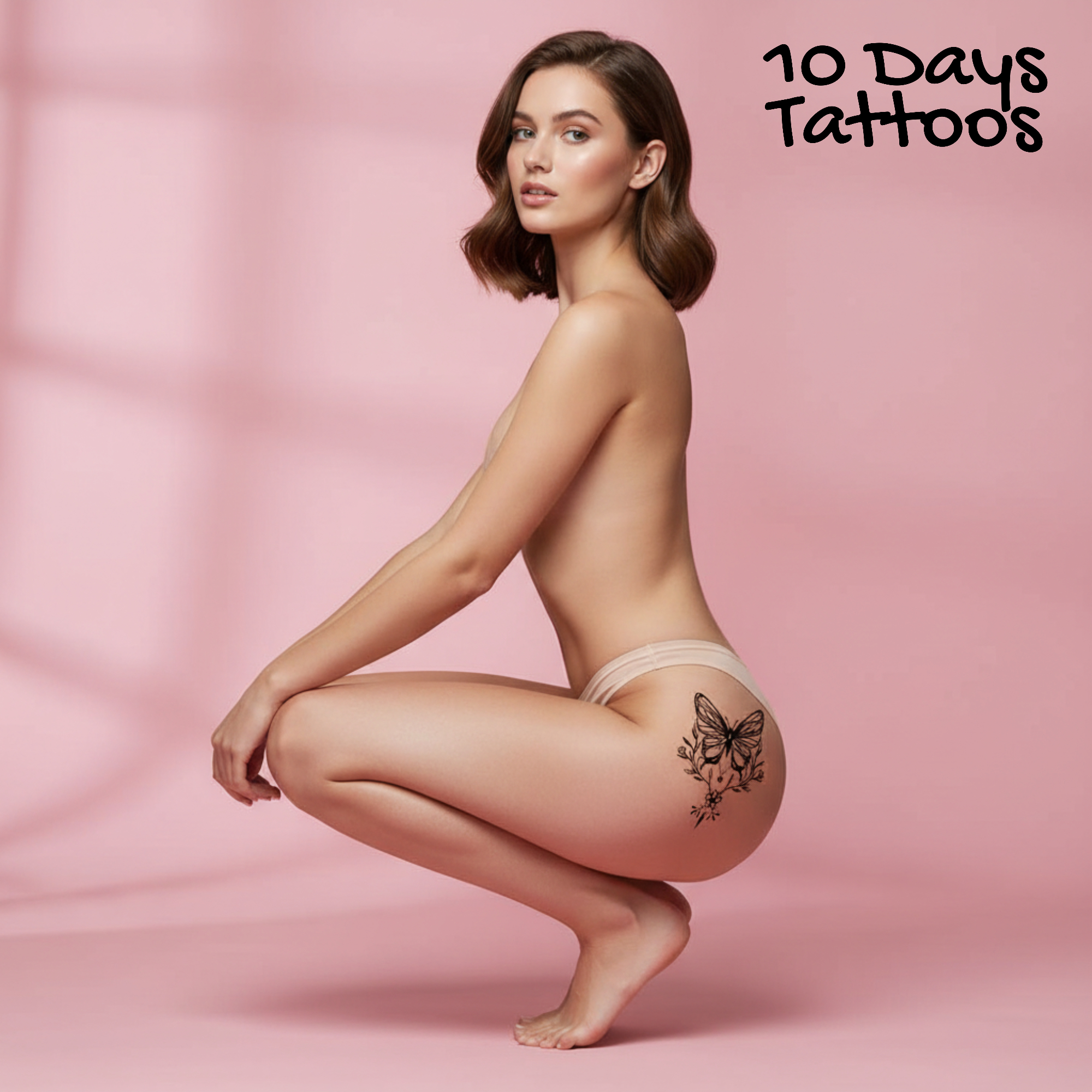 Tatouage temporaire papillon floral noir sur hanche et haut de la fesse d’une femme accroupie fond rose 10 Days Tattoos