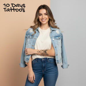 Tatouage temporaire papillon floral noir sur avant-bras d’une femme en jean veste en denim 10 Days Tattoos