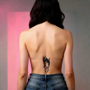 Deuxième modèle vue de dos, jean taille basse, tatouage temporaire Aku sur le bas du dos, visage oni féminin kanji 悪 style gravure japonaise 14 × 6 cm, encre noire mat, fond rose